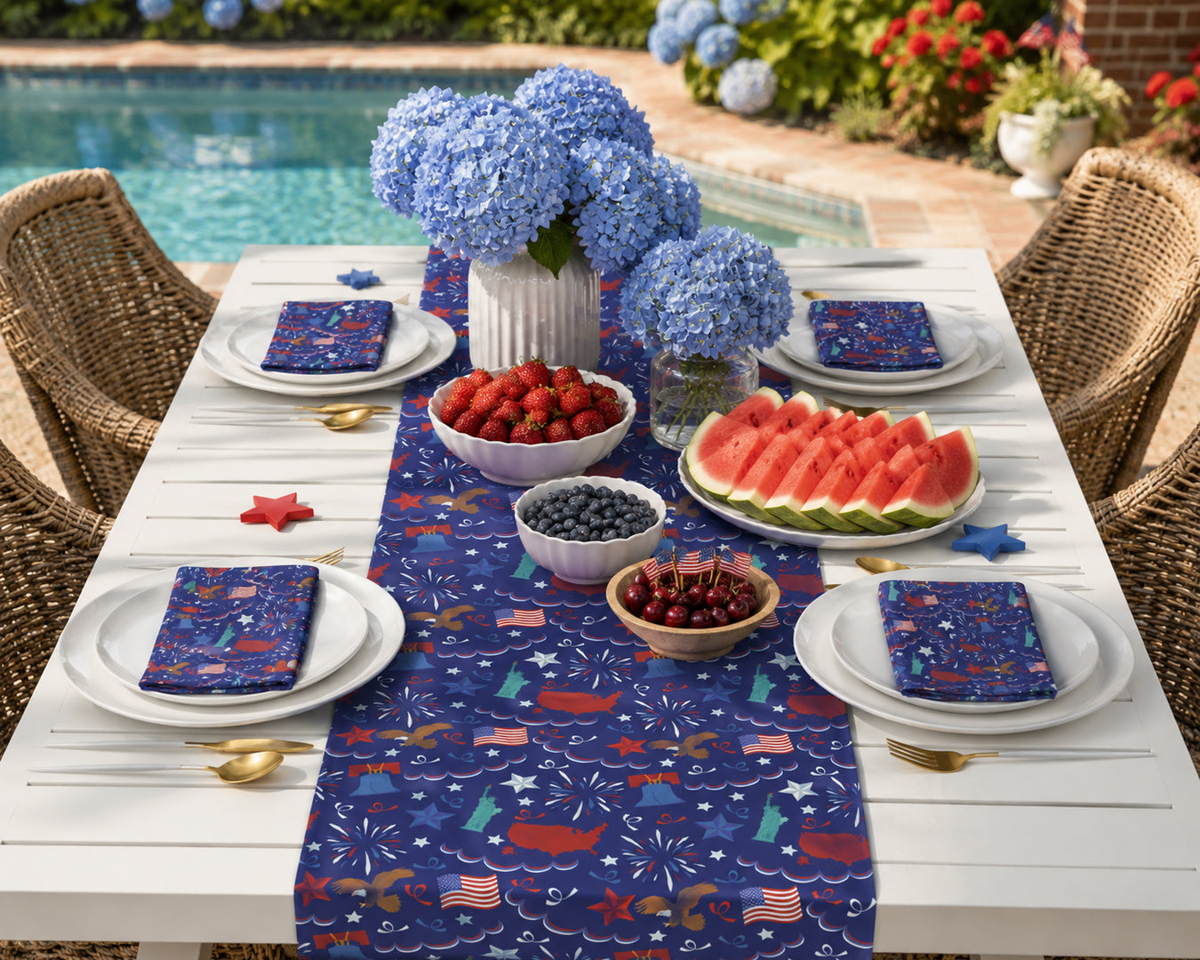 Outdoor table setting with a patriotic-themed tablecloth, plates, and fruit.