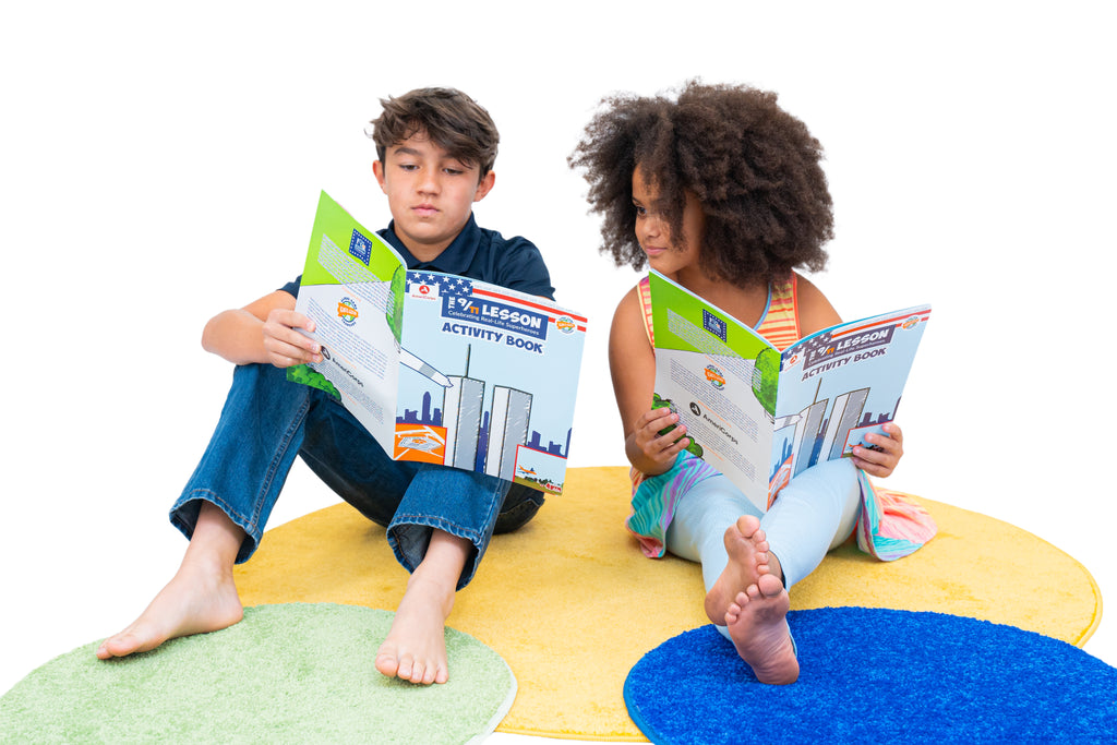 Two children sitting on a colorful rug reading 9/11 Lesson activity books together.