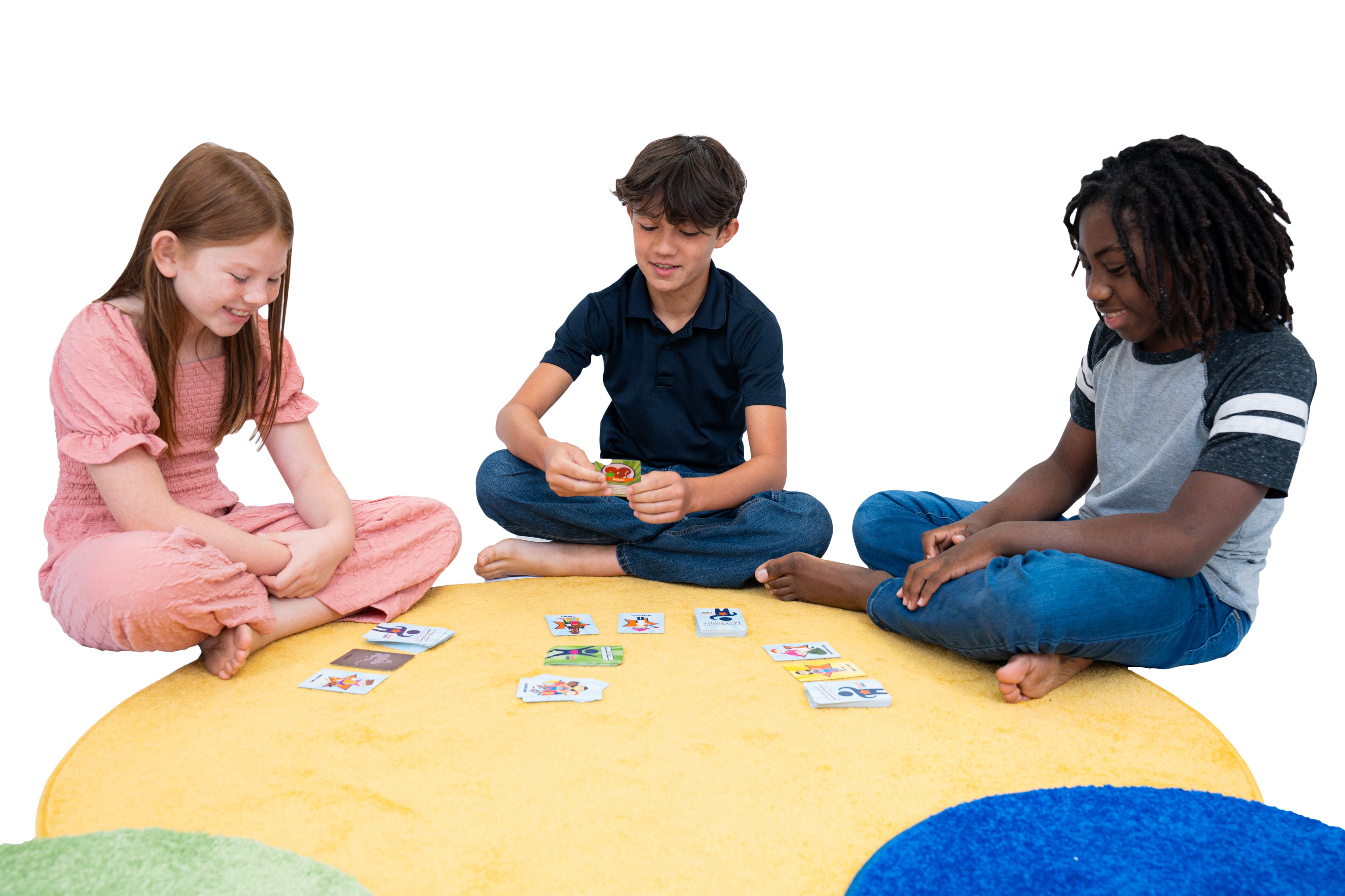 Three children sitting on a colorful rug playing with the What's Your Superpower? card game.