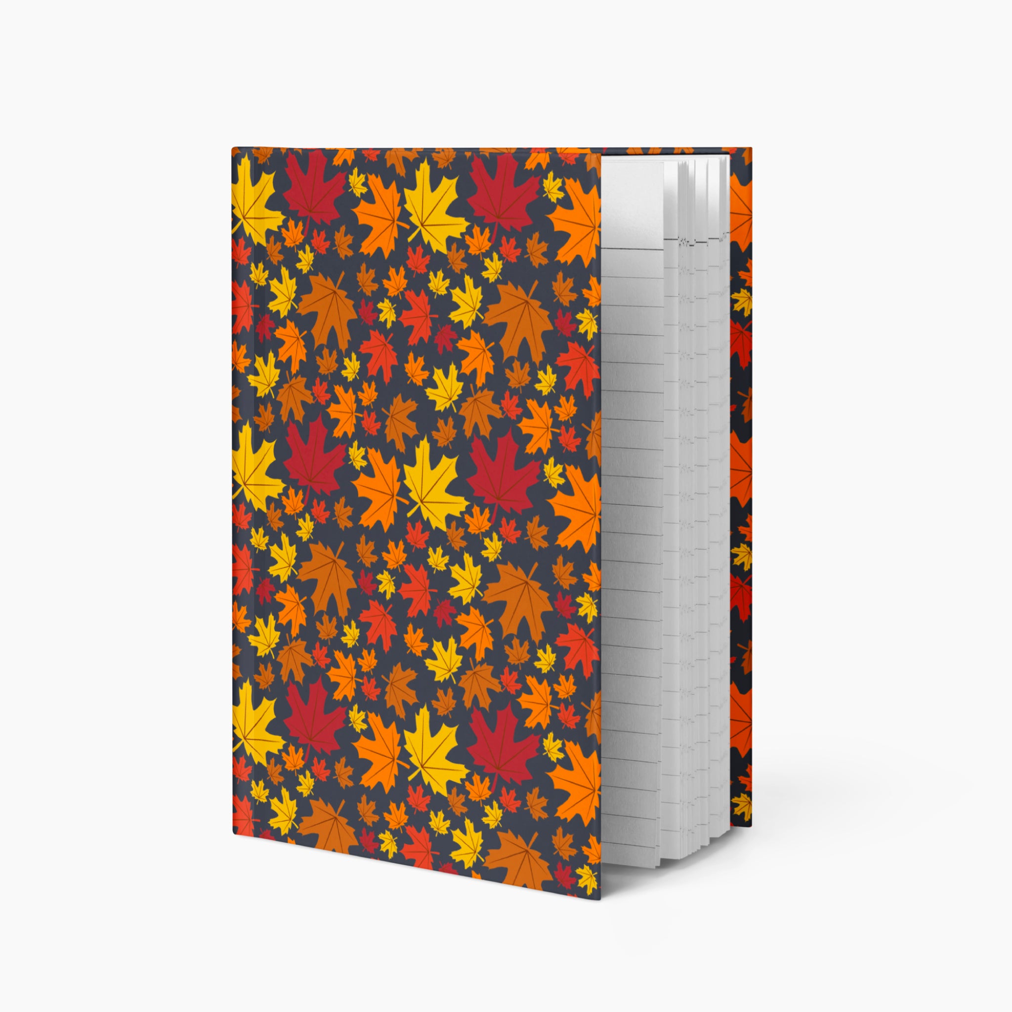 A notebook with a dark charcoal cover decorated with a dense pattern of colorful autumn maple leaves in red, orange, yellow, and brown, shown standing open against a light gray background.