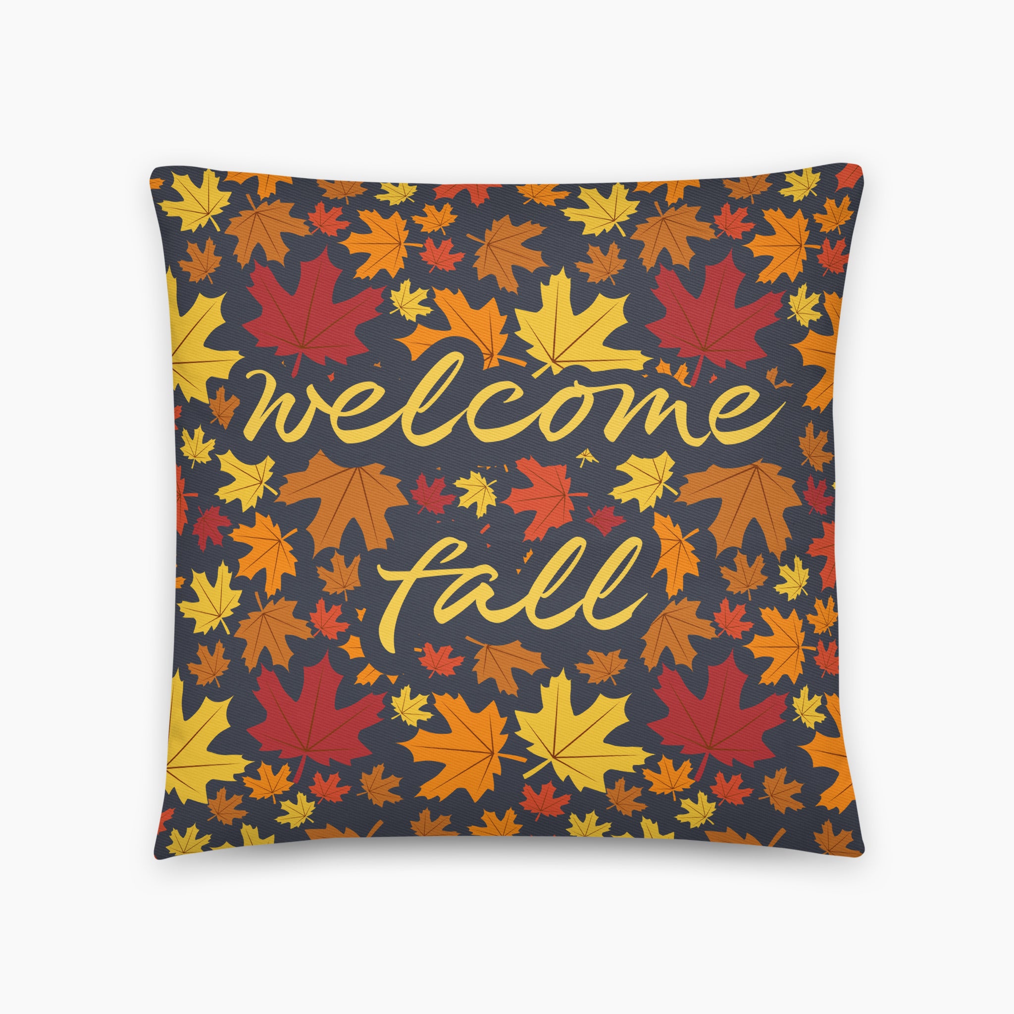 A square throw pillow featuring a dense pattern of colorful autumn maple leaves in shades of red, orange, yellow, and brown on a dark charcoal gray background, with a message that says "Welcome Fall" in script, shown against a plain light grey studio backdrop.