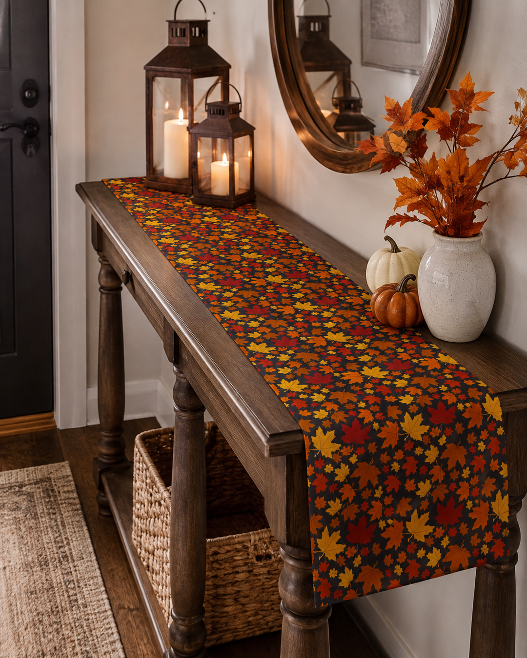 An autumn-themed table runner with a colorful maple leaf pattern in red, orange, yellow, and brown, styled on a dark wood console table in a home entryway setting.