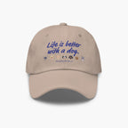 Beige cap with 'Life is better with a dog' text and dog icons on a white background