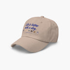 Beige cap with 'Life is better with a dog' text and dog icons on a white background