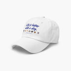 White cap with 'Life is better with a dog' text and dog icons on a white background