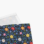 Blue Floral patterned cloth napkin close-up featuring colorful flowers on a dark blue on a white background