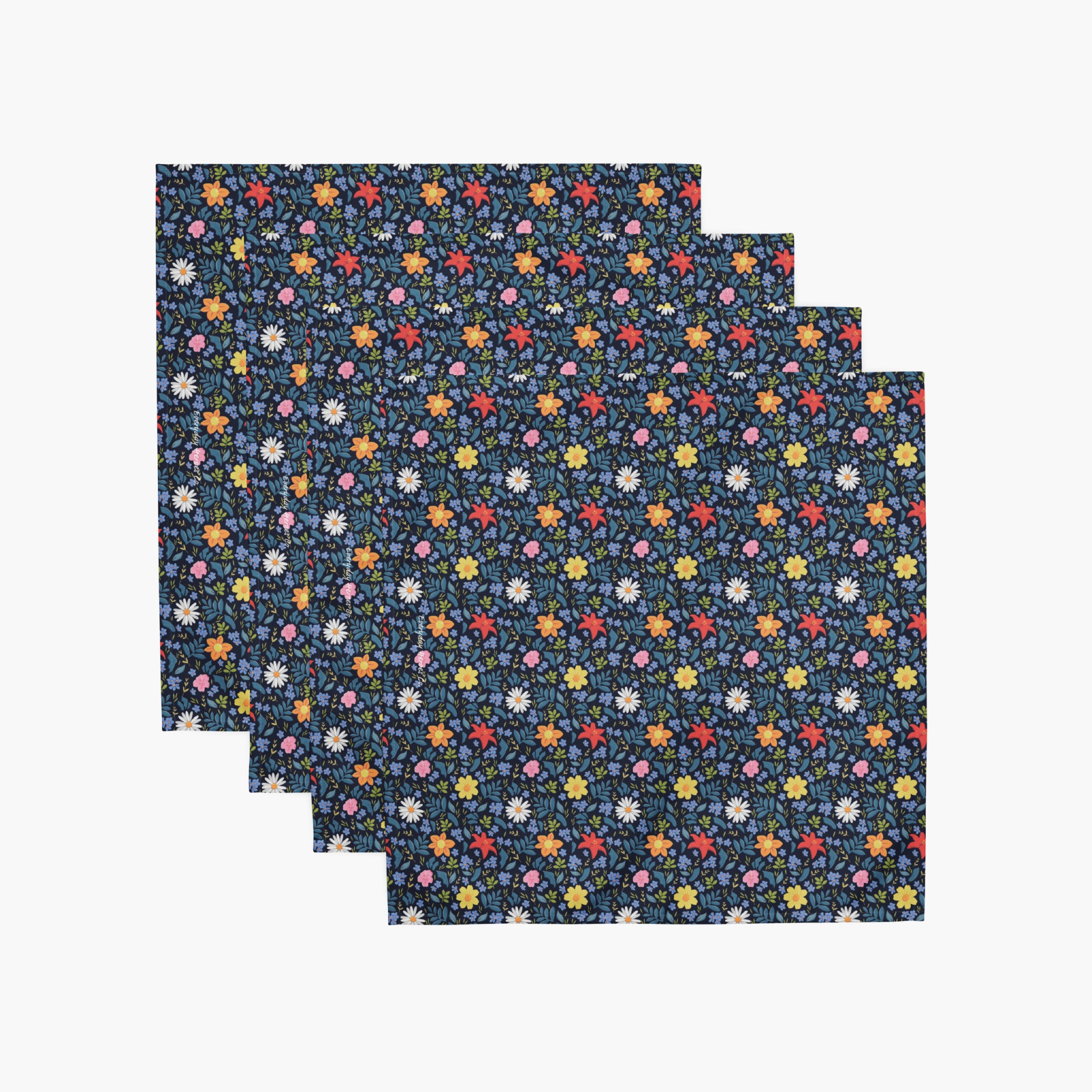 Set of four blue floral cloth napkins on a white background