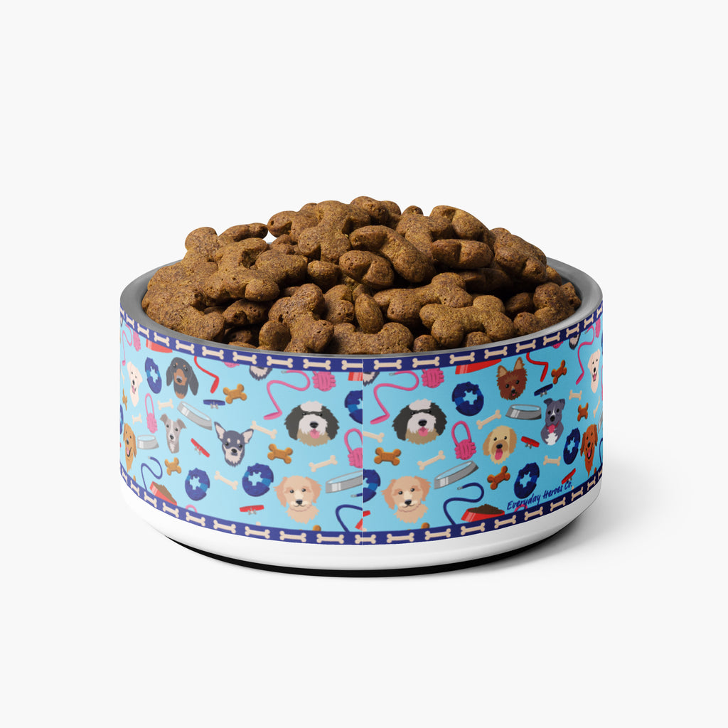 Dog food bowl with a custom blue dog gear pattern filled with kibble on a white background