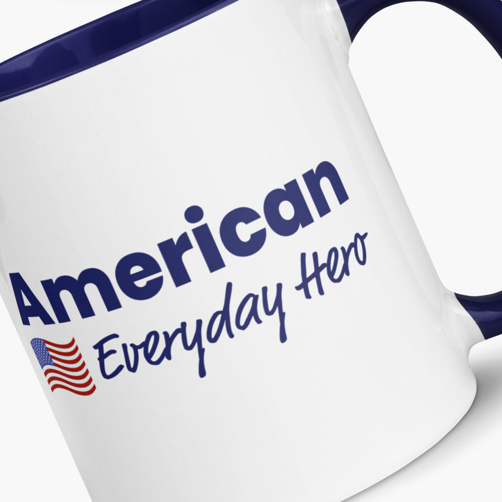 Close-up of a White mug with blue interior and handle, featuring 'American Everyday Hero' text and American flag.