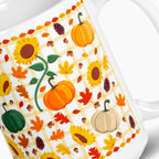 A close-up of a white ceramic mug decorated with an autumn pattern featuring pumpkins, sunflowers, maple leaves, acorns, pinecones, and a yellow-and-white gingham grid.