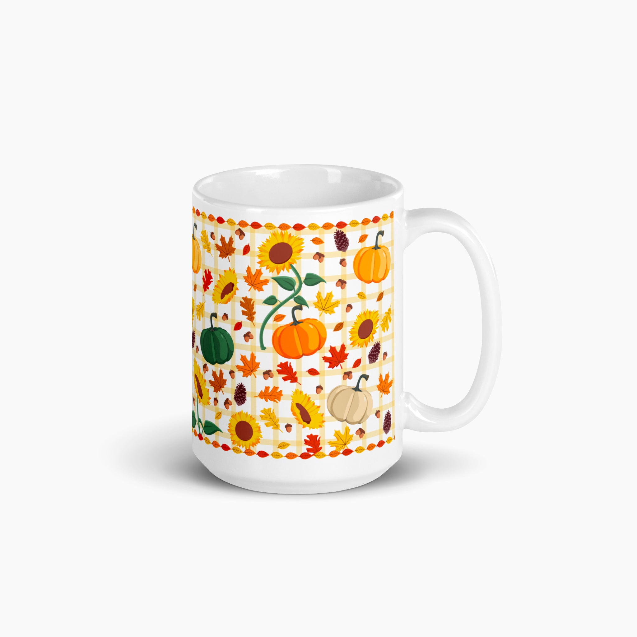 A white ceramic mug with a colorful autumn-themed pattern featuring pumpkins, sunflowers, maple leaves, and acorns, set against a light-grey background.