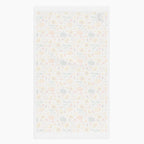 The white backside of rectangular dish towel featuring all-over autumnal leaf, pumpkin, and sunflower pattern, shown flat against a light gray background.