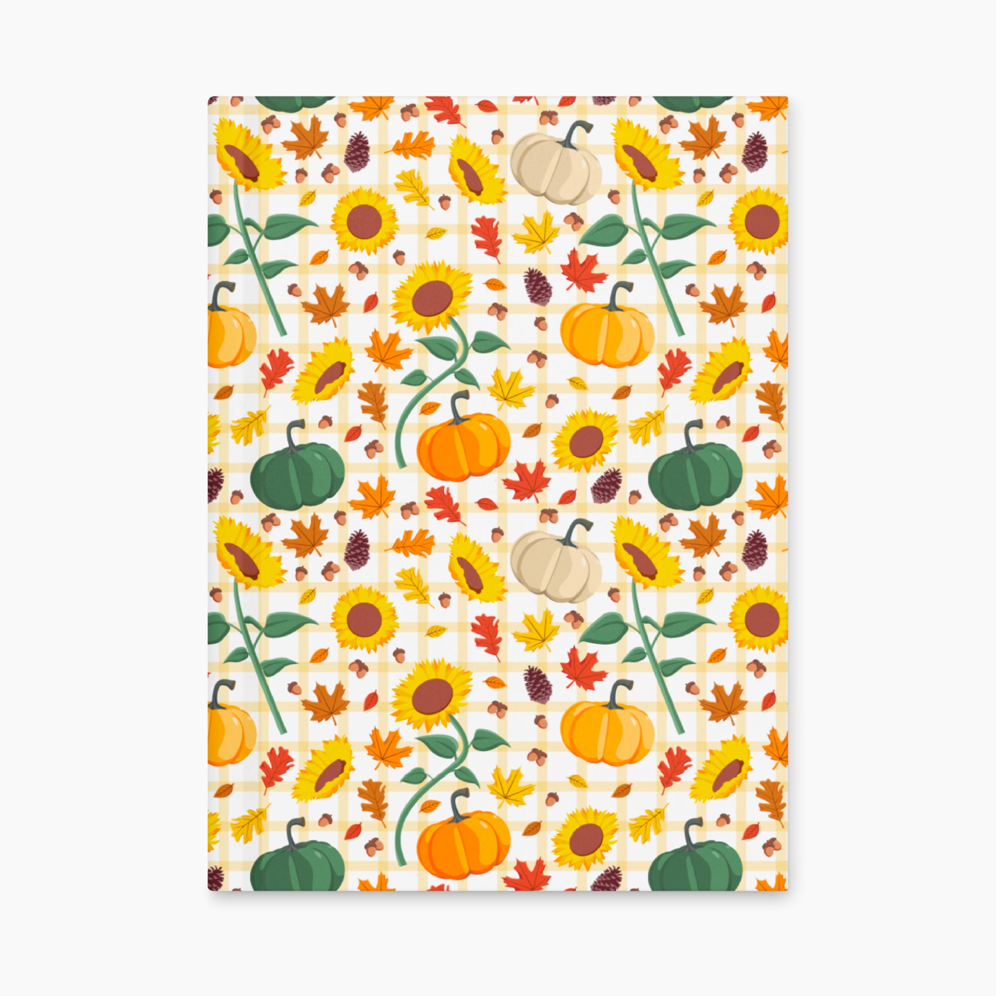 Front cover of a hardcover journal featuring a colorful autumn pattern of sunflowers, pumpkins, maple leaves, pinecones, and gingham checkered details on a light-grey background.