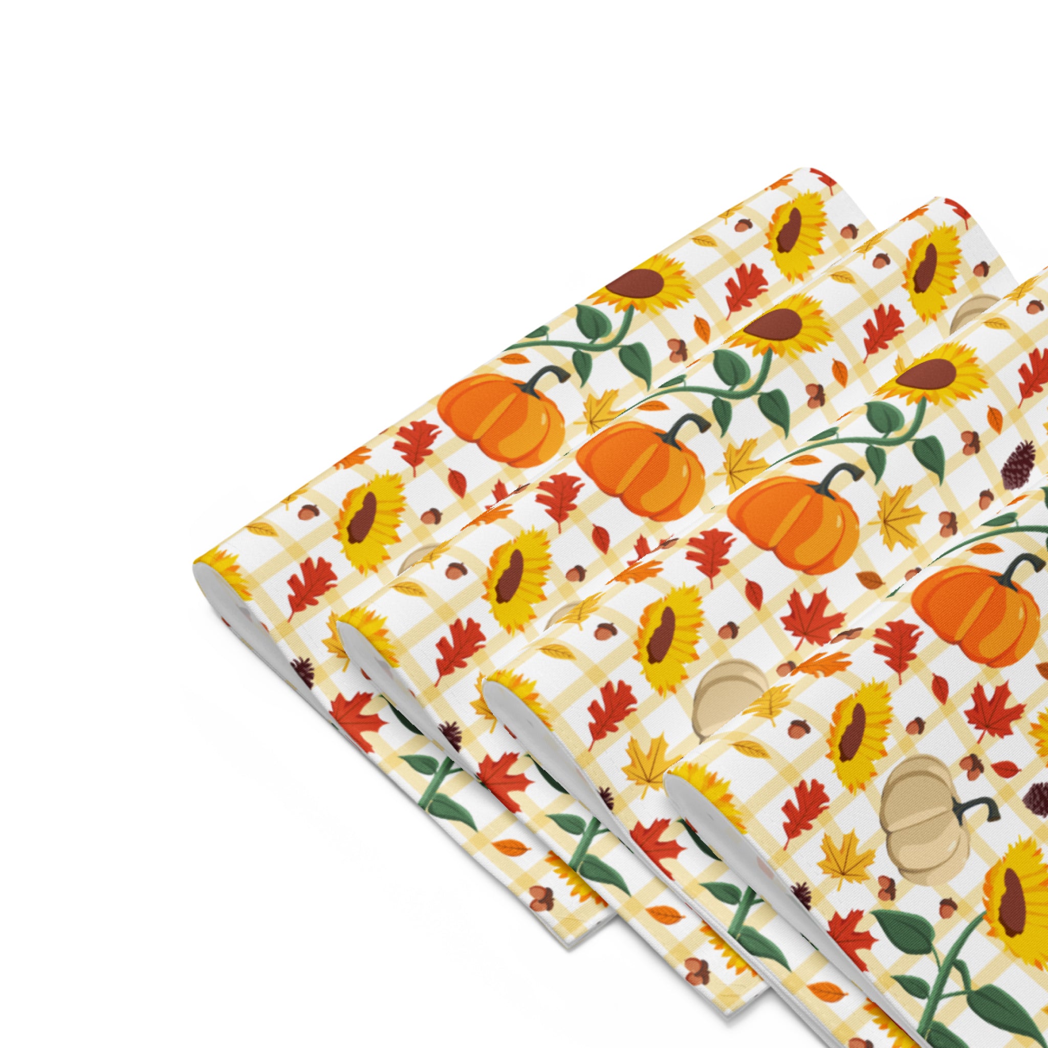 Set of 4 folded placemats with a colorful autumn pattern featuring pumpkins, sunflowers, maple leaves, and acorns on a light-grey background, arranged in a staggered stack.