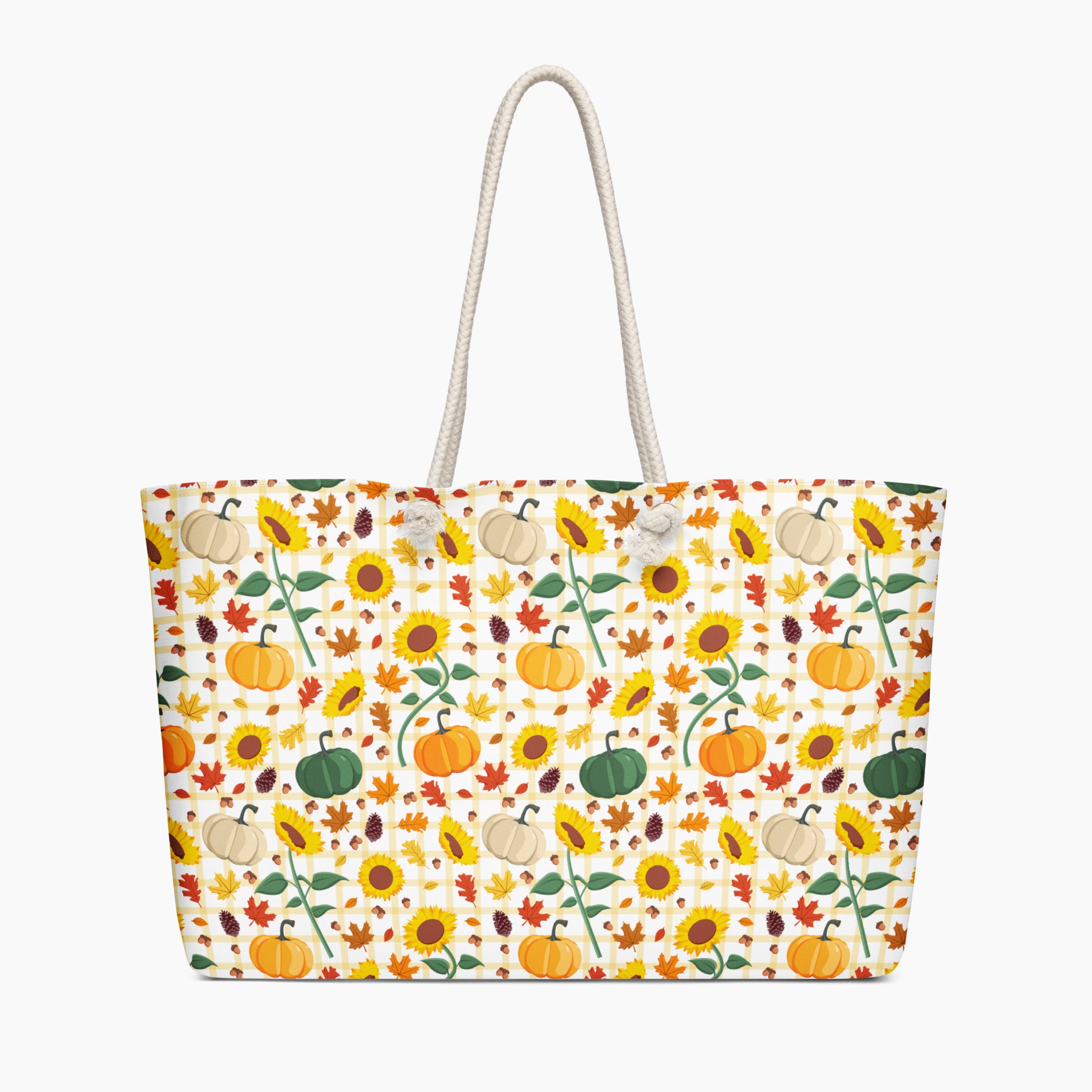 A tote bag with a white rope handle, featuring an all-over autumn pattern of pumpkins, sunflowers, maple leaves, and acorns on a light-grey background.