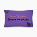 A rectangular purple throw pillow with a Halloween-themed design including a black bat and cat. The design features the text 'Sweet by nature. Spooky by Choice' staged on a light grey background.