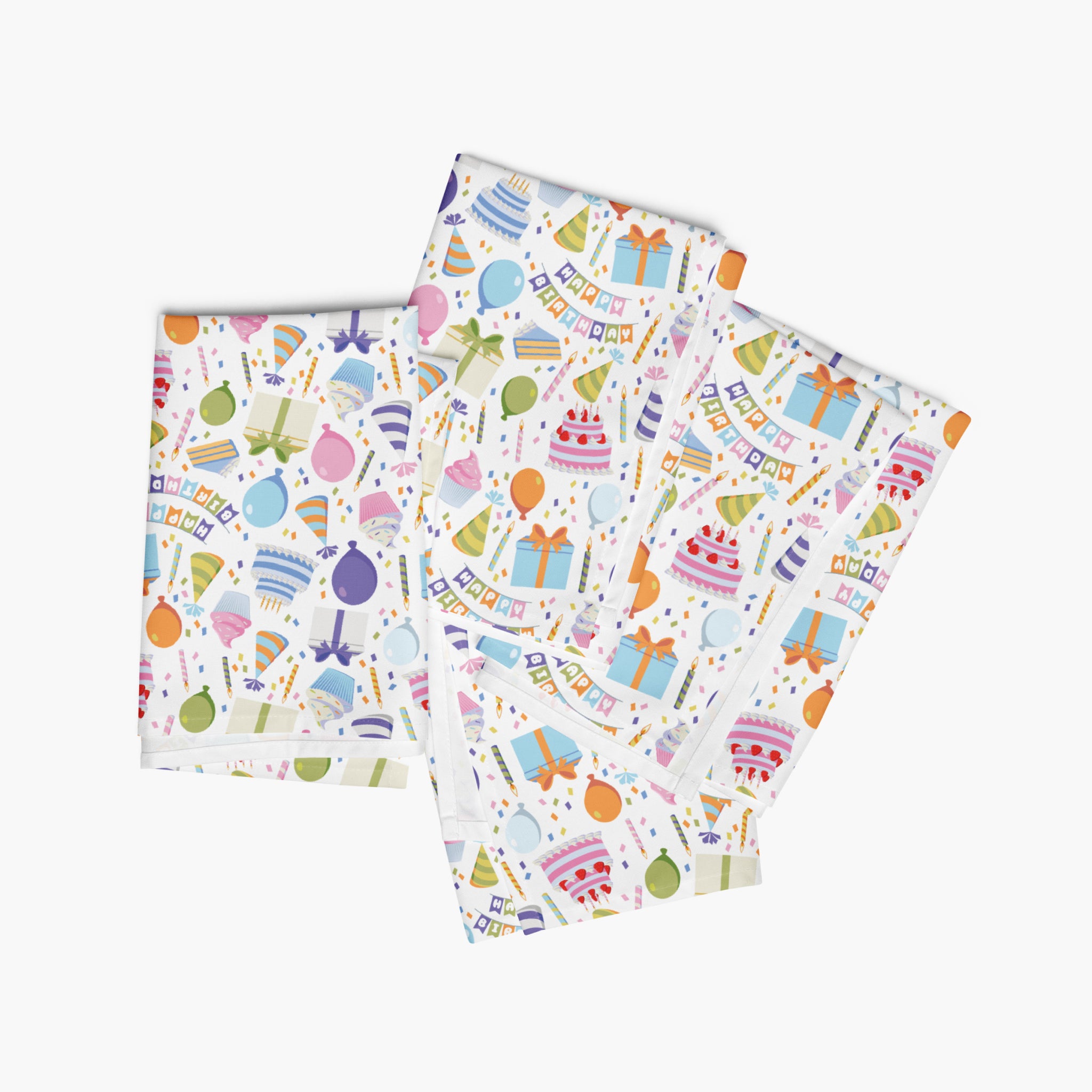 Four folded cloth napkins with a colorful pattern of birthday-themed illustrations on a white background.