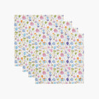 Four cloth napkins with a colorful pattern of birthday-themed illustrations on a white background.