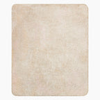 The sherpa backing of a rectangular blanket with rounded corners, featuring a soft, textured surface in a warm cream and light beige color, shown against a plain light grey background.