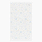 The white backside of a rectangular microfiber fabric hand towel with a repeating festive pattern featuring blue menorahs, blue Star of David motifs, blue circular medallions, gold stars, and small gold and blue doves shown flat against a light grey background