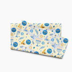 A folded microfiber fabric hand towel with a festive Hanukkah pattern on a cream background, featuring blue menorahs, Star of David motifs, dreidels, doves, and olive branches.