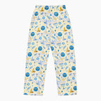 The back of a pair of pajama pants with a festive Hanukkah holiday print featuring blue menorahs, Star of David symbols, dreidels, olive branches, and doves on a pale yellow background, complete with a blue drawstring waist.