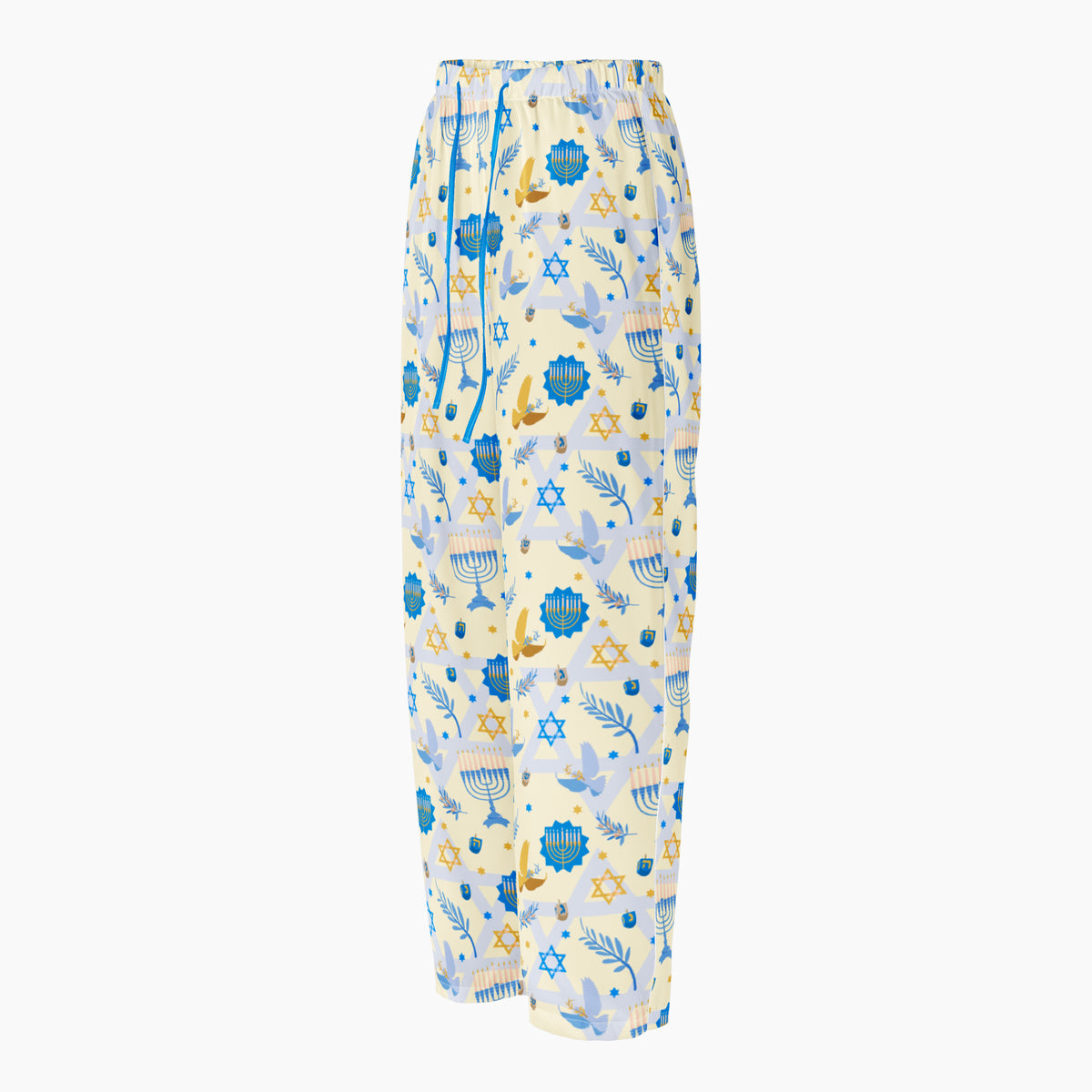 A pair of pajama pants with a festive Hanukkah holiday print featuring blue menorahs, Star of David symbols, dreidels, olive branches, and doves on a pale yellow background, complete with a blue drawstring waist shown from the side against a light grey studio backdrop.
