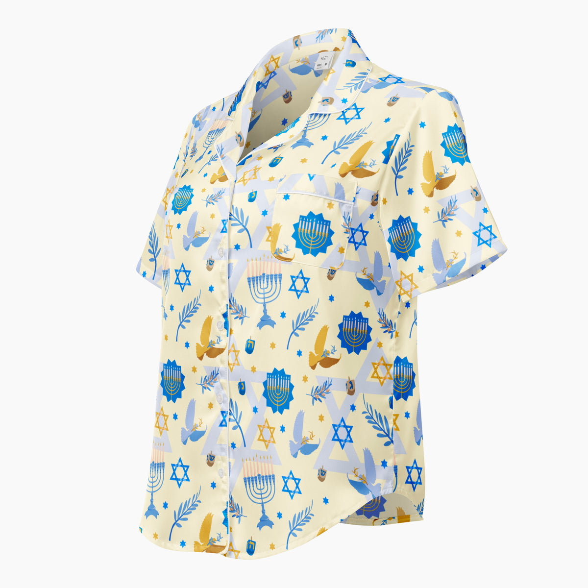 A short-sleeve button-up pajama shirt with a festive Hanukkah-themed print featuring blue menorahs, Star of David emblems, lulav and olive branches and gold and blue doves on a pale yellow background shown from the side against a light grey studio backdrop.