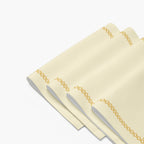 4 folded rectangular cream-colored fabric placemat with a decorative border. The border features a repeating gold Star of David pattern around the edges.