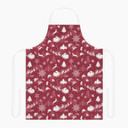 A deep red apron with a white winter holiday pattern featuring snowflakes, Christmas trees, reindeer, sleighs, and mountains, shown against a plain light grey background.
