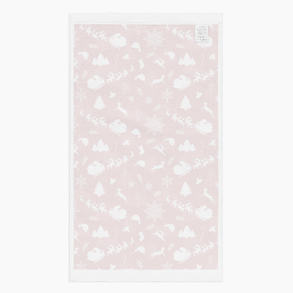 The white back of a rectangular deep red hand towel featuring a repeating white Christmas pattern with Santa Claus, sleighs, trees, snowflakes, and winter motifs, shown on a light gray background.