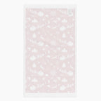 The white back of a rectangular deep red hand towel featuring a repeating white Christmas pattern with Santa Claus, sleighs, trees, snowflakes, and winter motifs, shown on a light gray background.