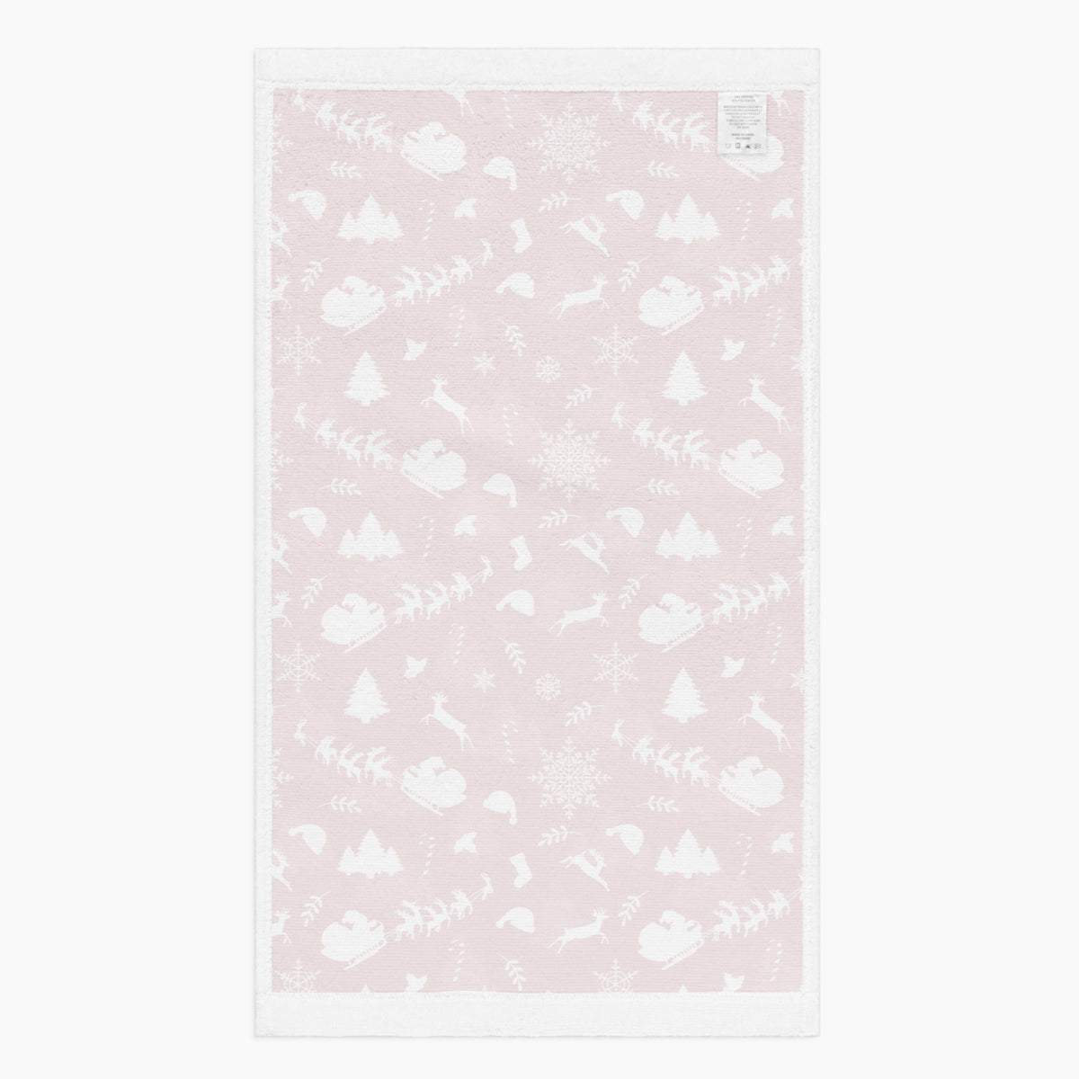 The white back of a rectangular deep red hand towel featuring a repeating white Christmas pattern with Santa Claus, sleighs, trees, snowflakes, and winter motifs, shown on a light gray background.