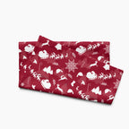 A folded deep red hand towel featuring a repeating white Christmas pattern with Santa Claus, sleighs, trees, snowflakes, and winter motifs, shown on a light gray background.