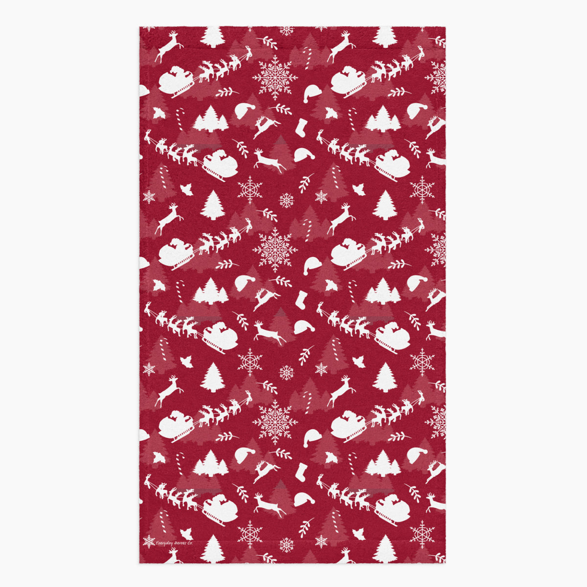 A rectangular deep red hand towel featuring a repeating white Christmas pattern with Santa Claus, sleighs, trees, snowflakes, and winter motifs, shown on a light gray background.