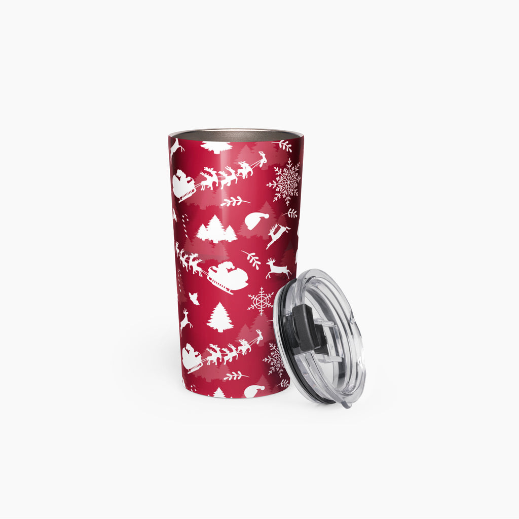 A deep red insulated travel tumbler with a white Christmas-themed pattern of sledding, trees, and snowflakes, shown next to its clear plastic lid on a white background.