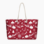 A deep red tote bag with a white Christmas-themed pattern featuring Santa Claus, reindeer, snowflakes, and trees, complete with two cream rope handles.