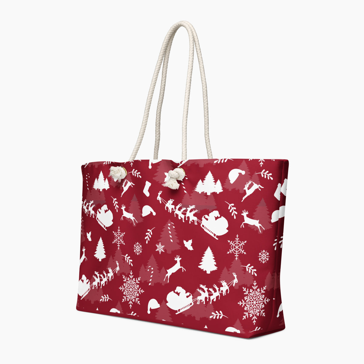 A deep red tote bag with a white Christmas-themed pattern featuring Santa Claus, reindeer, snowflakes, and trees, complete with two cream rope handles.