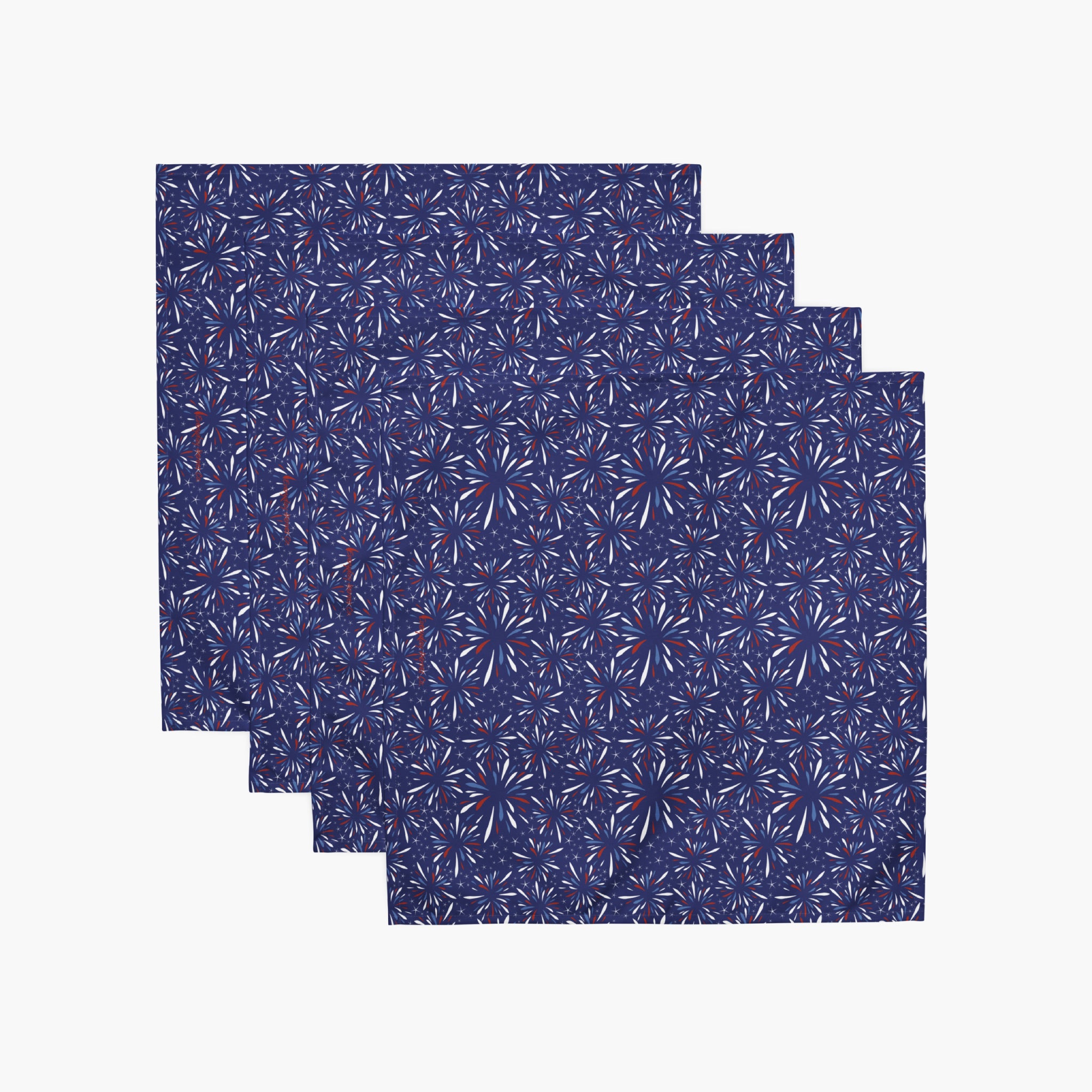 Four cloth napkins with a colorful pattern of firework-themed illustrations on a white background.