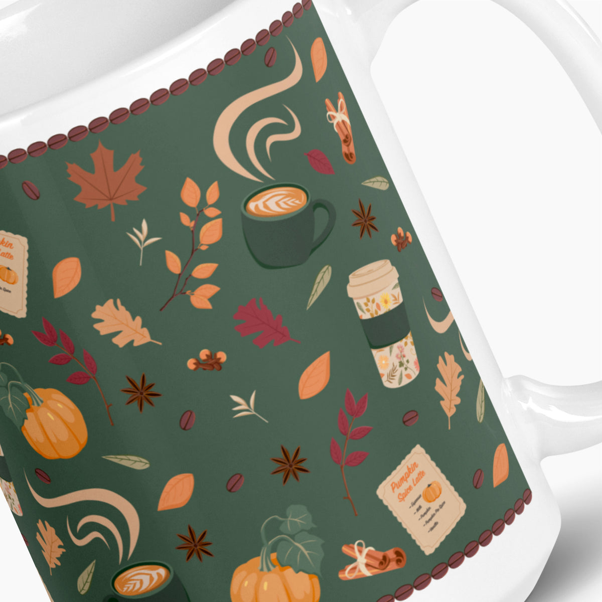 A close-up of a white ceramic mug featuring a pumpkin spice coffee-themed pattern. The pattern includes illustrated pumpkins, leaves, coffee cups, coffee beans, cinnamon sticks, and other fall motifs on a dark green background.