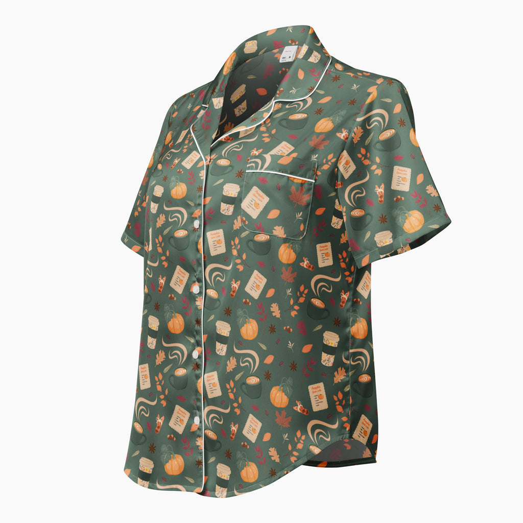 A short-sleeve button-up pajama shirt in sage green with a whimsical pumpkin spice pattern of pumpkins, autumn leaves, and coffee cups, finished with white piping.