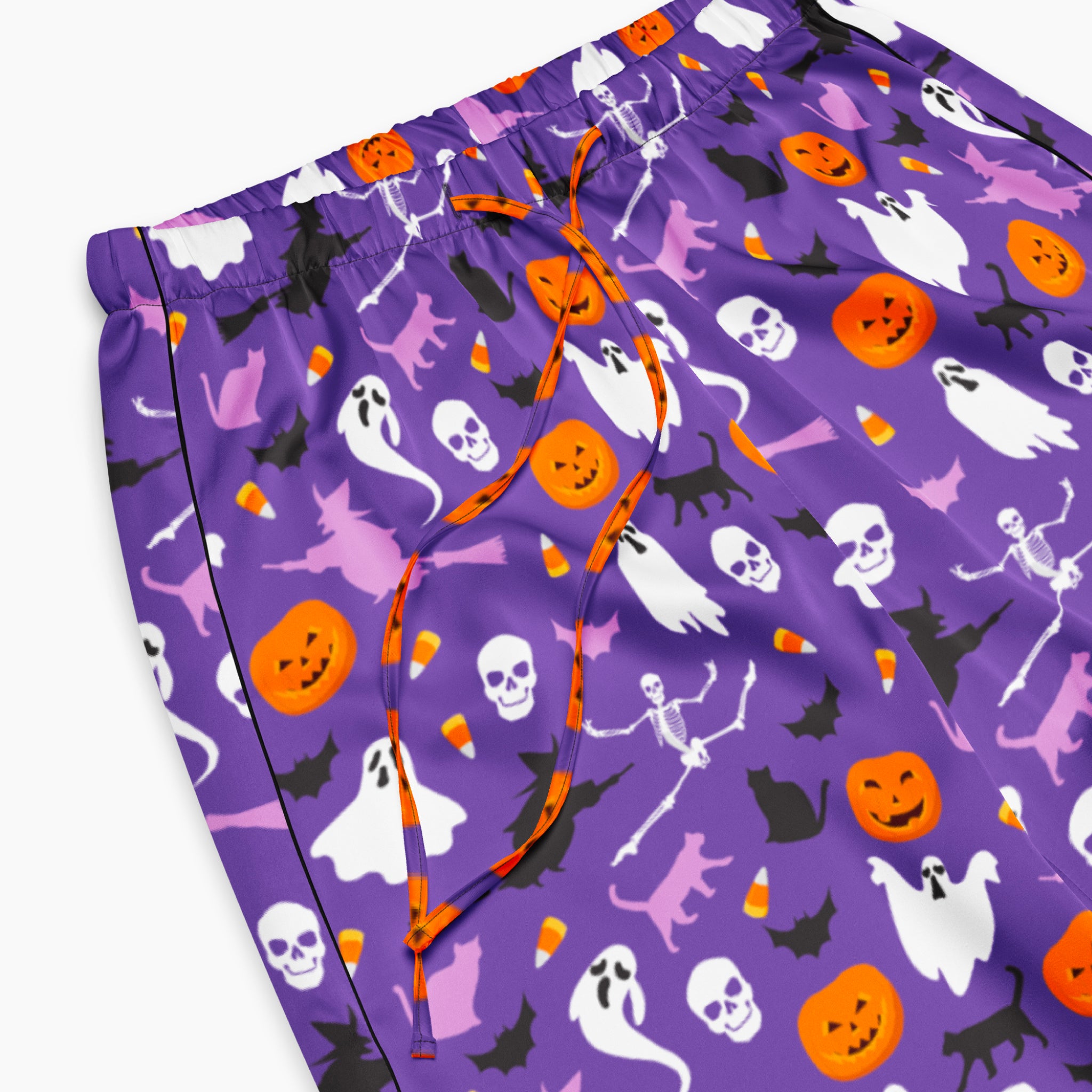 Close-up view of Purple Halloween-themed pajama pants with an all-over print of white ghosts, orange pumpkins, black bats, and purple witch, shown flat against a light gray background.