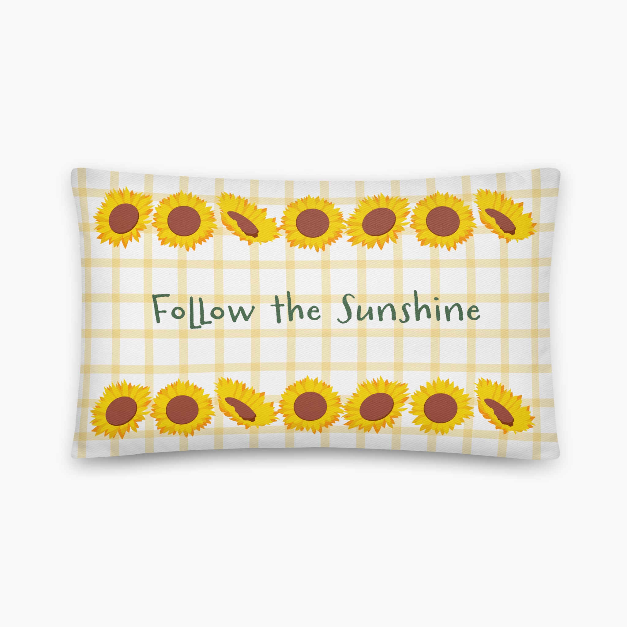 A rectangular throw pillow with a white and pale yellow gingham pattern, decorated with yellow sunflower illustrations and the phrase 'Follow the Sunshine' in green text, staged on a light grey studio background.