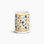 White mug with colorful teacher-themed pattern on a white background