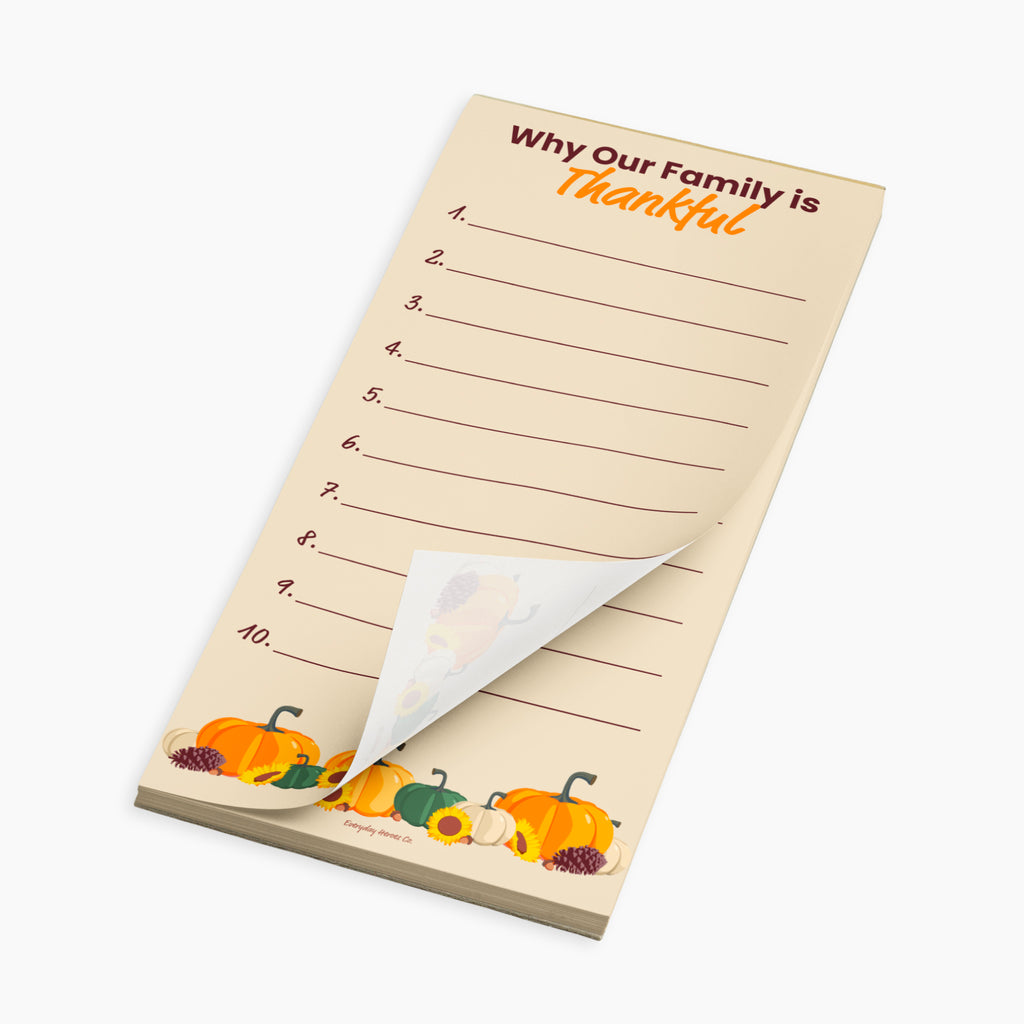 A family reflection notepad with a Thanksgiving theme, featuring the text 'Why Our Family is Thankful' and numbered lines from 1 to 10. The pad has a warm beige background with illustrations of pumpkins and gourds along the bottom edge, and a curled-back bottom-right corner showing the white backing paper.