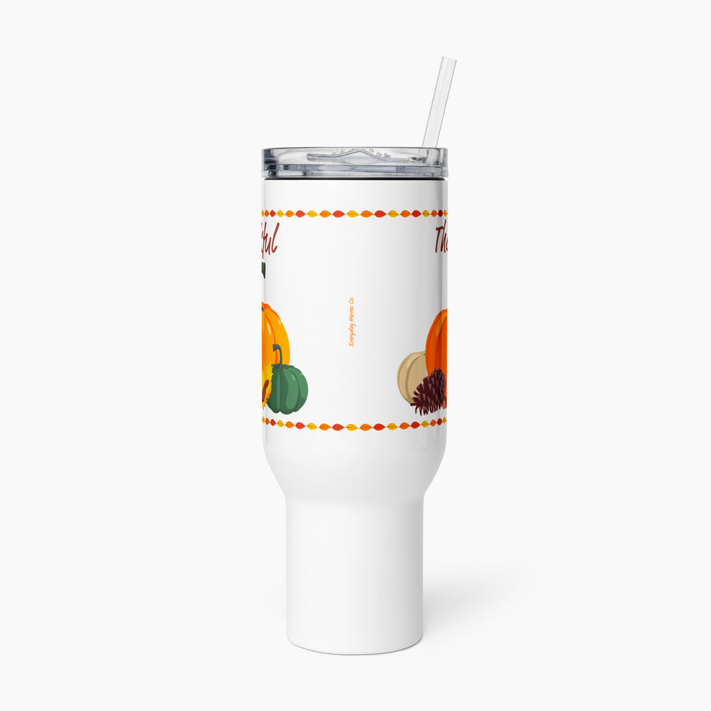 A white insulated travel tumbler with a clear lid and straw, featuring a fall harvest design with pumpkins and autumn-themed text, shown on a light gray background.
