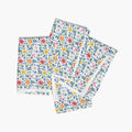 Four white floral-patterned cloth napkins stacked on a white background