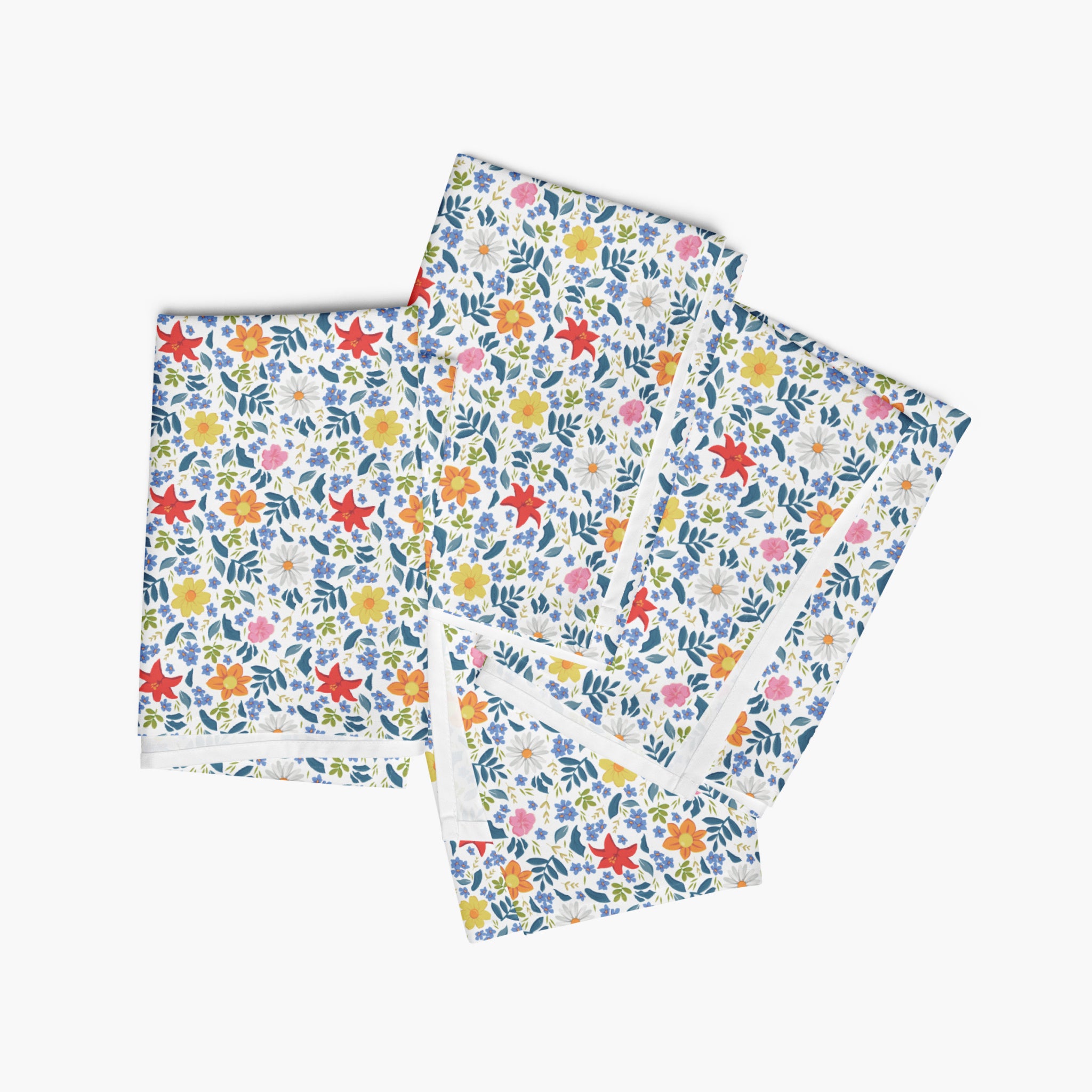 Four white floral-patterned cloth napkins stacked on a white background